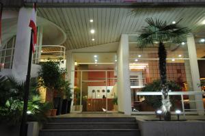 a lobby with stairs and a palm tree in front of a building at Suite Hotel Chrome - Beirut in Beirut