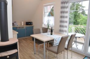 a kitchen and dining room with a table and chairs at Ferienhaus Müritzzauber / OG-Appartement in Marienfelde