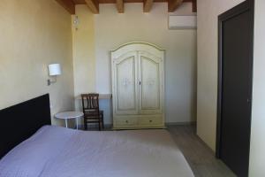 1 dormitorio con 1 cama, armario y mesa en B&B Ai Prati, en Lesignana