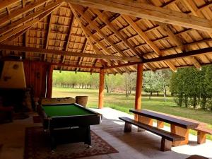 a wooden pavilion with a pool table and a bench at Miodowy Zakątek Całoroczne Domki i Pokoje przy Suntago, Deepspot, Pyszne Śniadania, Grill in Mszczonów