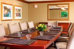 une salle de conférence avec une grande table et des chaises en bois dans l'établissement Wyndham Omaha Hotel - West Dodge, à Omaha