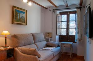 ein Wohnzimmer mit einem Sofa und einem Fenster in der Unterkunft Casa Piñana in Anciles