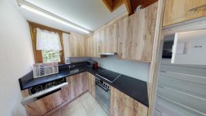 布拉藤貝納特斯的住宿－Tschuggen 24，厨房配有木制橱柜和炉灶烤箱。
