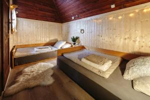 Habitación con 2 camas en una habitación con paredes de madera. en Chalet Tisa Velika Planina, en Stahovica