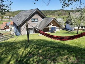 a hammock in a yard in front of a house at Ferienwohnung Bergele in Rot an der Rot