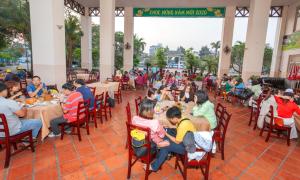 een groep mensen die aan tafel zitten in een restaurant bij KHÁCH SẠN BẾN ĐÁ NÚI SAM in Chau Doc