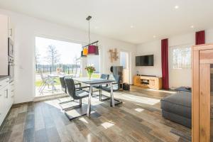 a kitchen and living room with a table and chairs at Neu!!! Ferienhaus-See-Sauna-Kamin-5 Sterne-102m² in Krakow am See