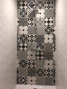 baño con una pared de azulejos en blanco y negro en Maison d'hôtes MIRADOUR, en Tarnos