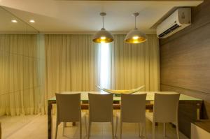 
a dining room table with chairs and a lamp at Dream Home Maceio in Maceió
