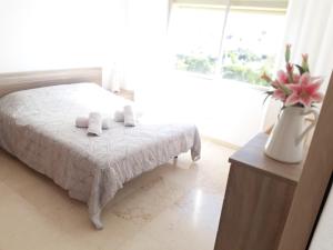 a bedroom with a bed and a vase with flowers at urbanización puerto paraiso in Estepona +12 photos