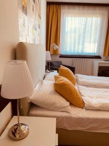 a bedroom with two beds and a lamp on a table at Hotel Gloria Budapest City Center in Budapest