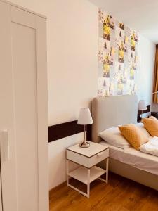 1 dormitorio con 1 cama y 1 mesa con lámpara en Hotel Gloria Budapest City Center en Budapest