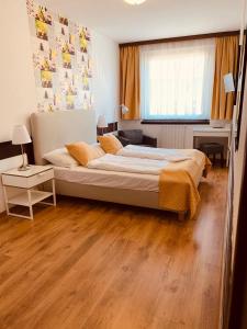 um quarto com uma cama grande e piso em madeira em Hotel Gloria Budapest City Center em Budapeste