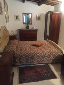een slaapkamer met een bed, een dressoir en een spiegel bij Villa Anna Savini Casa Vacanze in Atri