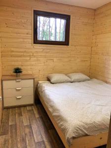 um quarto com uma cama e uma janela em Świerkowy domek em Boszkowo