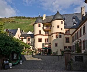 a large white building with a black roof at Hotel Schloss Zell in Zell an der Mosel