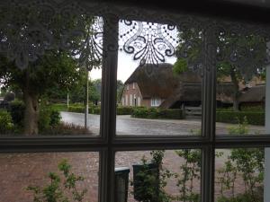 a view of a courtyard from a window at Vakantiehuis An Diek in Staphorst