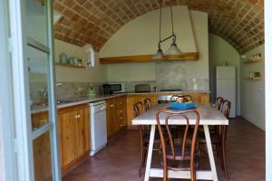 a kitchen with a table and some chairs in it at Cal Germa at Can Campolier in Banyoles