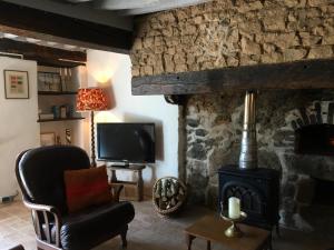 sala de estar con fogones y TV en Les Bouaux, Bardon, en Cussy-en-Morvan