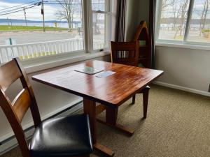 霍利的住宿－East Shore Lodging，窗户客房内的一张木桌和椅子