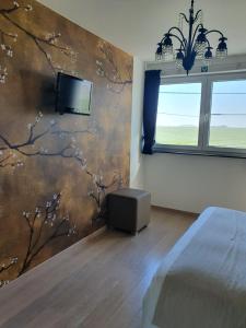 Un dormitorio con una pared con un mural de un árbol en B&B Kanegem Onverbloemd en Tielt