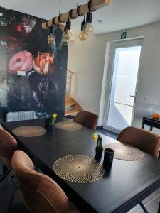 a dining room with a black table and chairs at B&B Kanegem Onverbloemd in Tielt