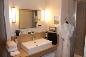 a bathroom with a sink and a mirror at Hôtel jardin Le Pasteur in Châlons-en-Champagne