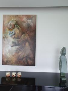 una pintura en una pared con una estatua al lado en B&B Kanegem Onverbloemd en Tielt