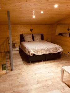 - une chambre avec un lit dans une cabane en bois dans l'établissement Le duplex De La Ferme Du Tertre, à Villers-au-Tertre