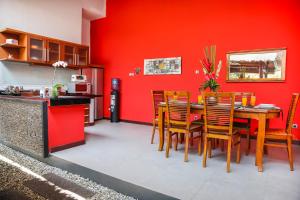 a dining room with red walls and a table and chairs at Villa Ayu in Seminyak