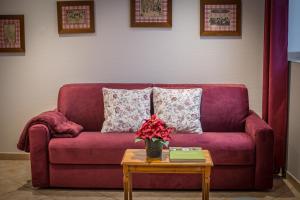 a purple couch with a table and a vase with flowers at Gite **** des Bains in Strasbourg