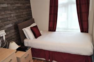 Habitación pequeña con cama y ventana en Gable End Hotel, en Great Yarmouth