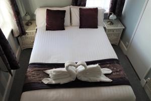 two swans are laying on a bed at Gable End Hotel in Great Yarmouth