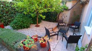 a patio with a table and chairs and a tree at Morena in Pula
