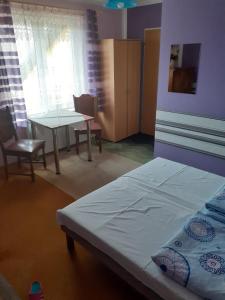 a bedroom with a bed and a table and chairs at Noclegi u Eugenii in Licheń Stary