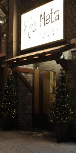 Un letrero de meca en un edificio con árboles de Navidad delante en Hotel Meta, en Pas de la Casa