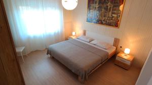 a small bedroom with a bed and a window at Morena in Pula
