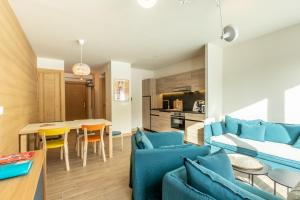 阿爾克1600的住宿－LE RIDGE Résidence Premium - Les Arcs Paradiski，客厅配有蓝色的沙发和桌子