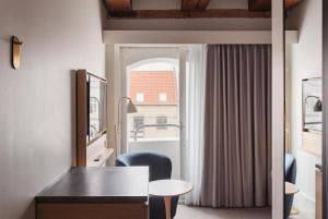 a room with a desk and chairs and a window at Copenhagen Admiral Hotel in Copenhagen
