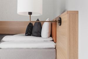 a bed with black and white pillows on it at Copenhagen Admiral Hotel in Copenhagen