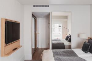 a bedroom with two beds and a tv and a mirror at Copenhagen Admiral Hotel in Copenhagen