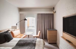 a hotel room with a bed and a chair and a table at Copenhagen Admiral Hotel in Copenhagen