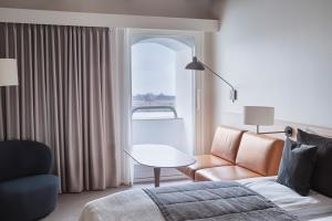 a living room with a couch and a table and a window at Copenhagen Admiral Hotel in Copenhagen