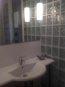 a white sink sitting under a mirror in a bathroom at Coral Reef Guesthouse in Fort Lauderdale