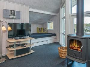 a living room with a fireplace and a tv at 8 person holiday home in Ebeltoft in Ebeltoft
