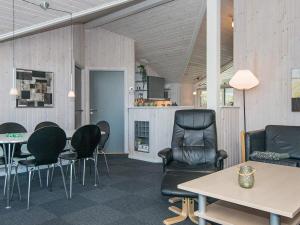 エーベルトフトにある8 person holiday home in Ebeltoftのリビングルーム(黒い椅子、テーブル付)