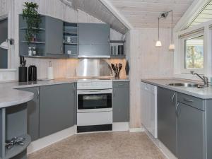 a kitchen with gray cabinets and a sink at 8 person holiday home in Ebeltoft in Ebeltoft