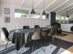 Skødshoved Strand的住宿－6 person holiday home in Knebel，一间用餐室,配有黑色的桌子和椅子