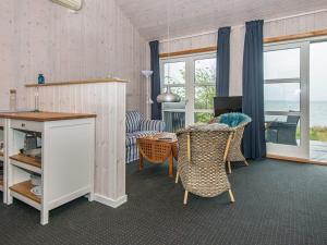 un soggiorno con tavolo, sedie e divano di One-Bedroom Holiday home in Bjert 1 a Sønder Bjert