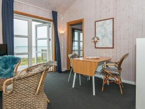 una sala da pranzo con tavolo, sedie e finestre di One-Bedroom Holiday home in Bjert 1 a Sønder Bjert